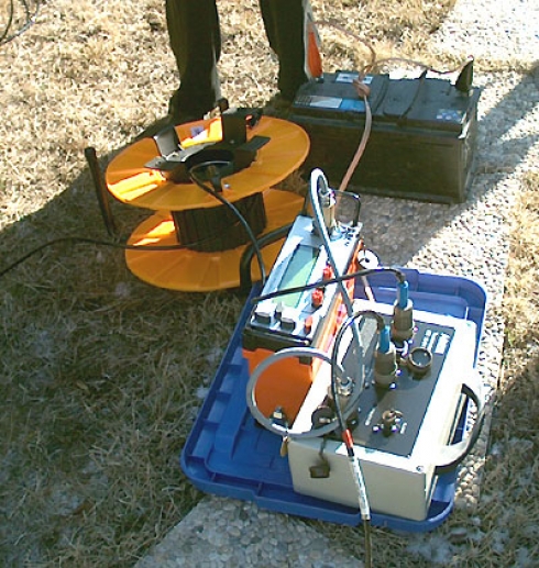 Imagen en la que se muestra el resistivímetro SAS 1000 junto a varios accesorios apoyados en el suelo