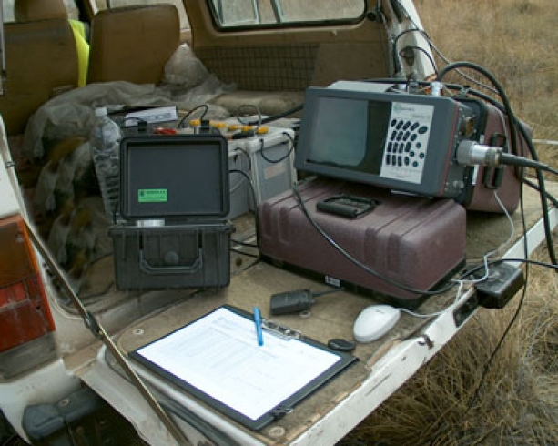 Imagen en la que se muestra un sismógrafo Rollalong junto a otros accesorios apoyados en el maletero de un coche